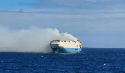 Заброшенный в огне грузовой корабль, наполненный автомобилями, дрейфует в Атлантическом океане