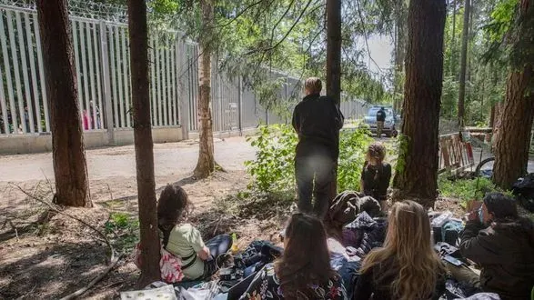 Мігранти з дітьми застрягли біля прикордонної стіни Польщі. білорусь не дає їм повернутись назад