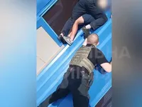 Поліцейські карколомно визволили чоловіка, який застряг на даху висотки у Києві