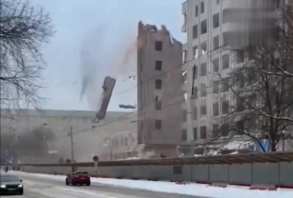 a-wall-nearly-covered-people-and-cars-a-wall-collapsed-during-the-demolition-of-a-university-building-in-russia