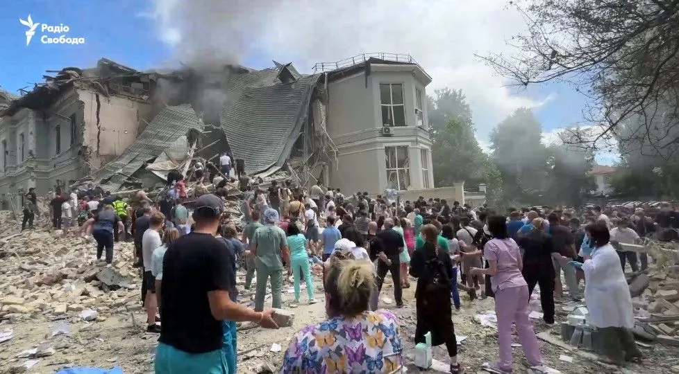 People dismantle the rubble of the Okhmatdyt building, which was hit by a russian missile