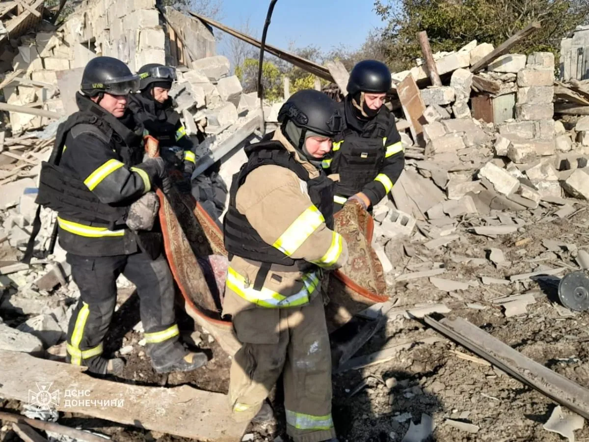 Rescuers remove a woman's body from the rubble of a house in Yantarne village, Donetsk region